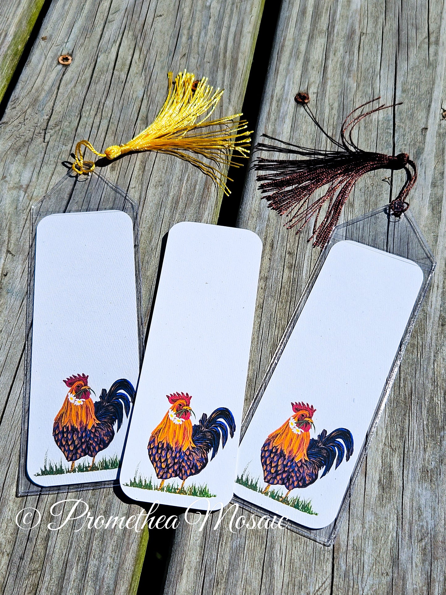Display of 'Love Rooster' bookmarks with center one showing how it looks with no sleeve or tassel
