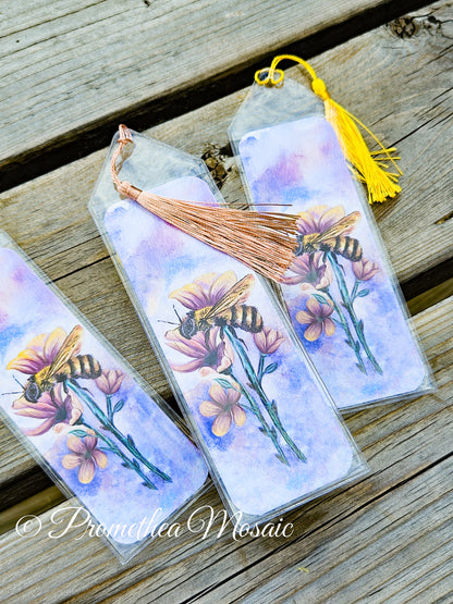 Bookmarks with bee and flower design on a wooden surface, featuring the brand 'Promethea Mosaic'.