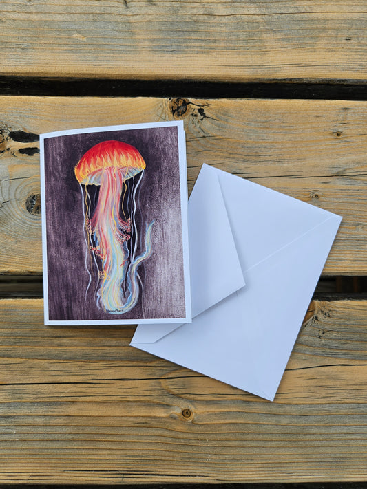 Greeting card with jellyfish illustration and envelope on wooden surface