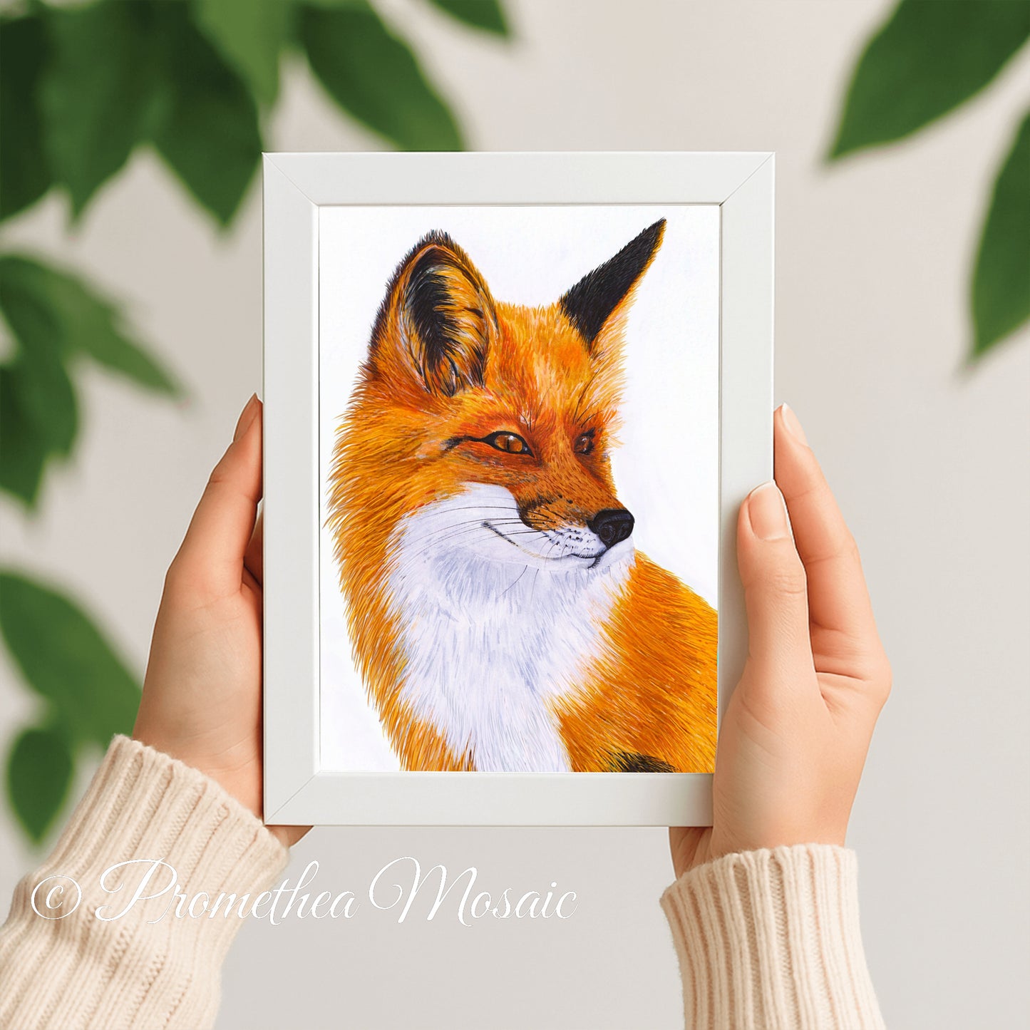 Framed artwork of a fox held by hands with a light background