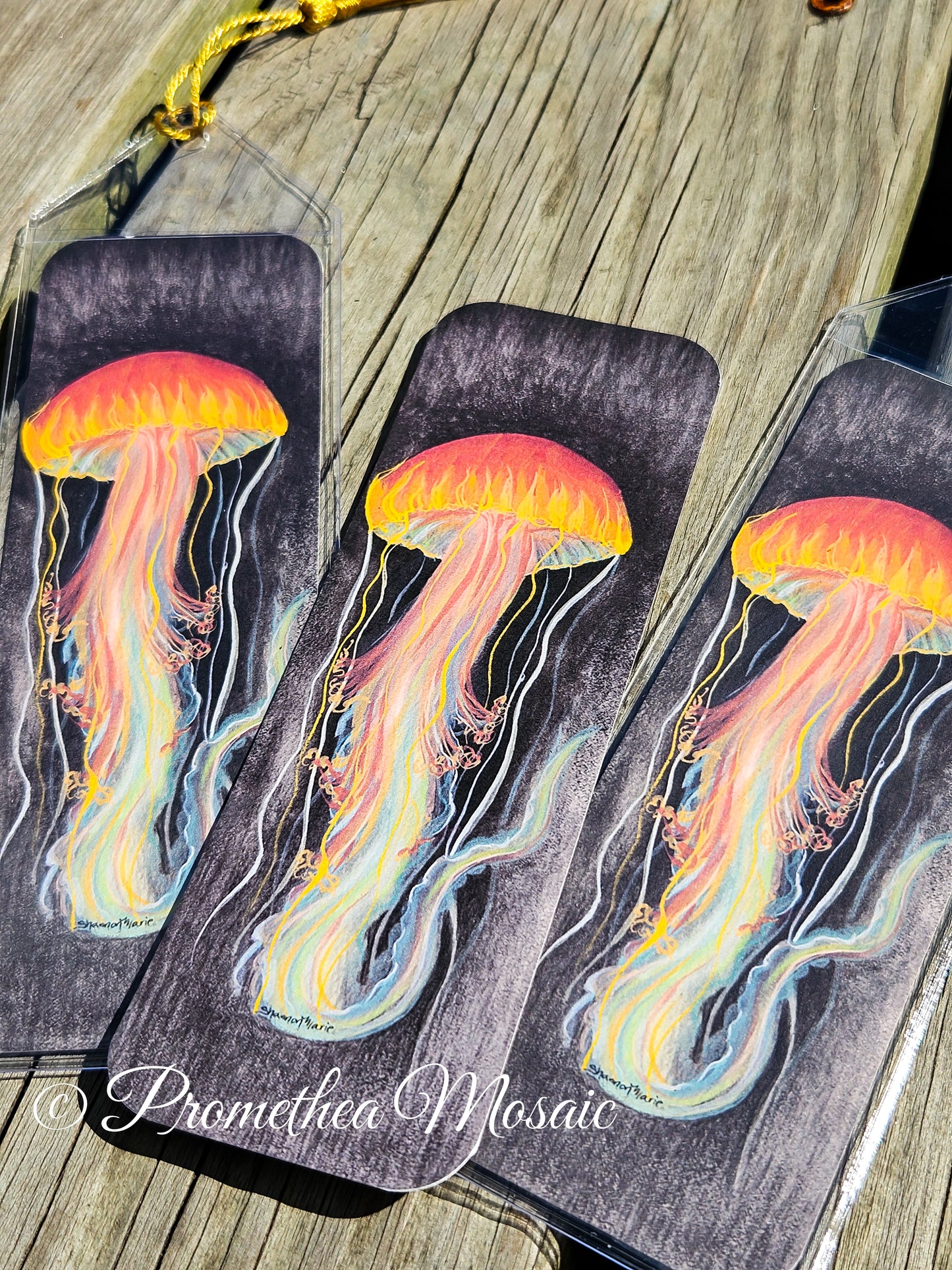 display of three brightly painted jellyfish bookmarks with reusable plastic sleeves and tassels
